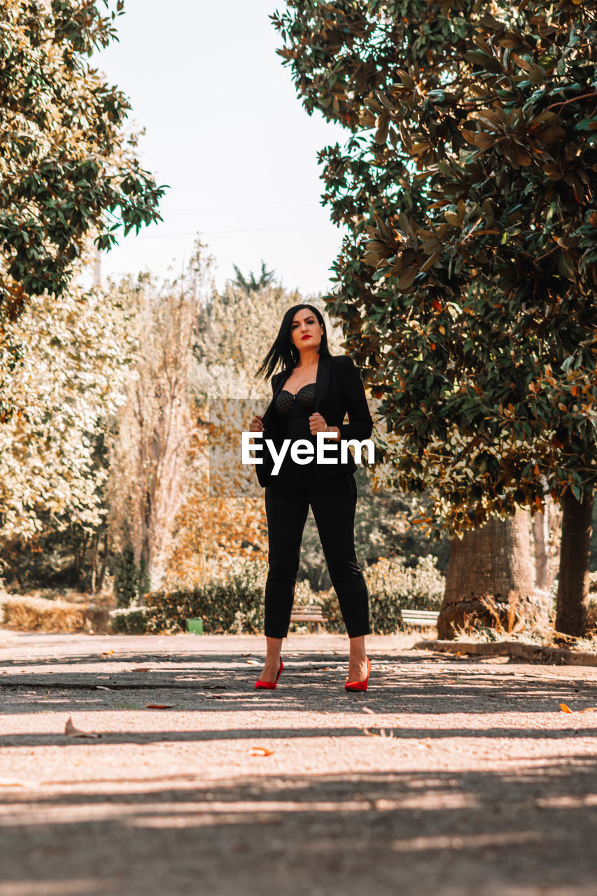 Portrait of female model standing on footpath at park