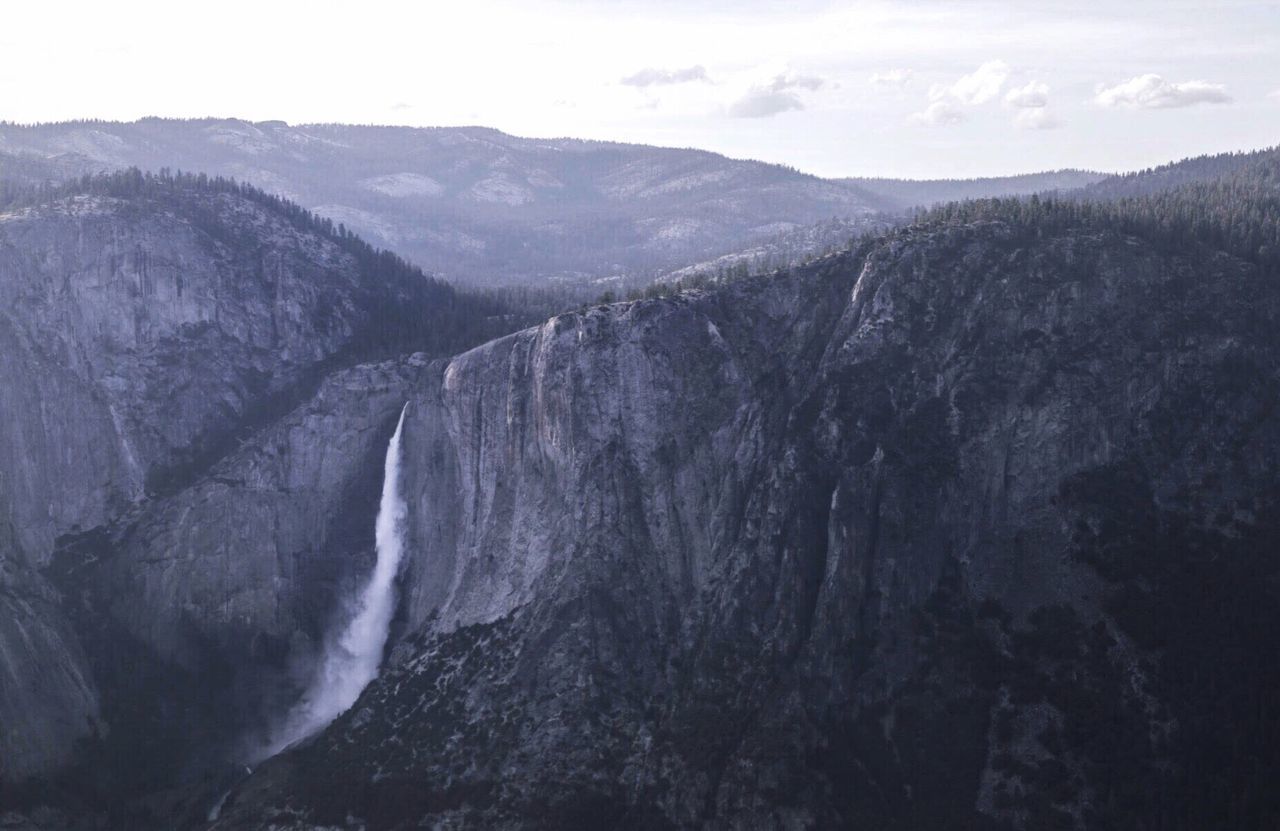 Scenic view of waterfall against sky