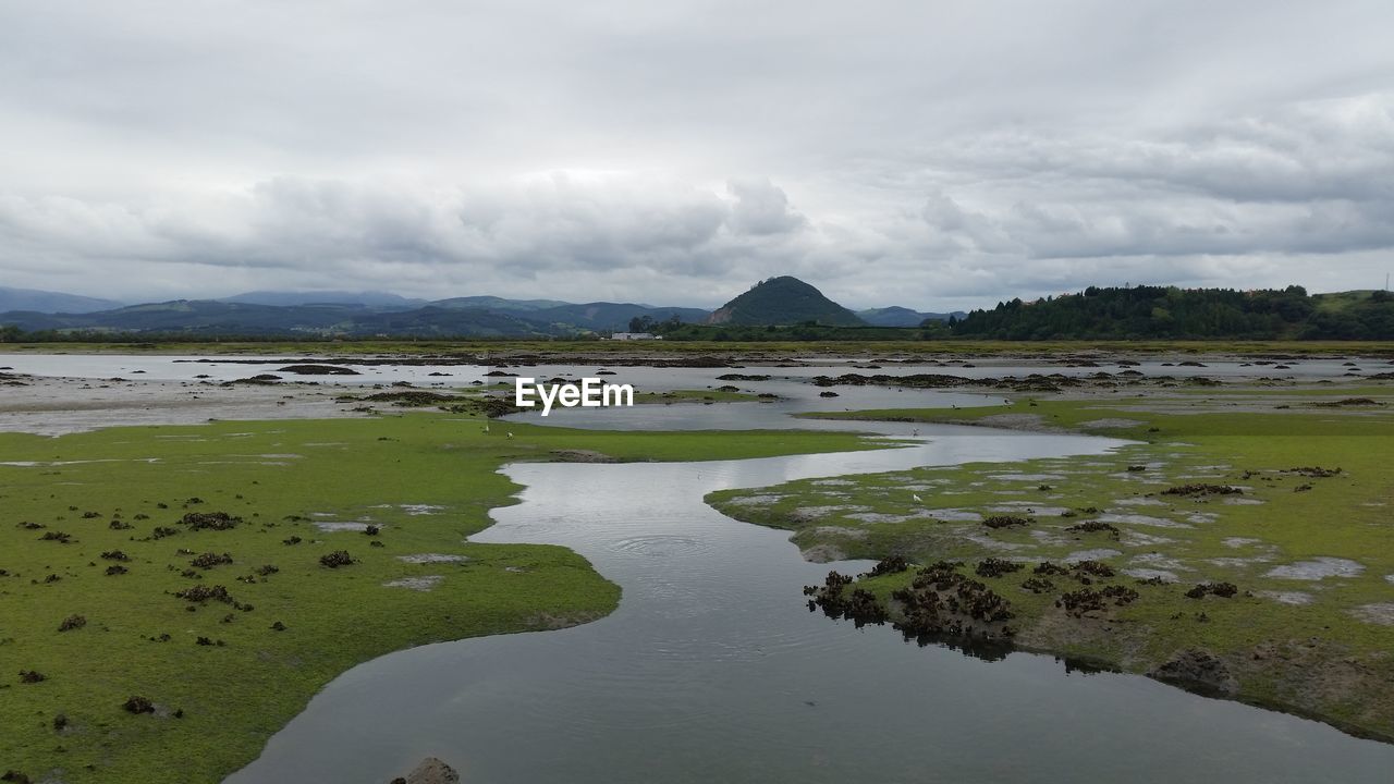 SCENIC VIEW OF LAKE BY MOUNTAIN AGAINST SKY