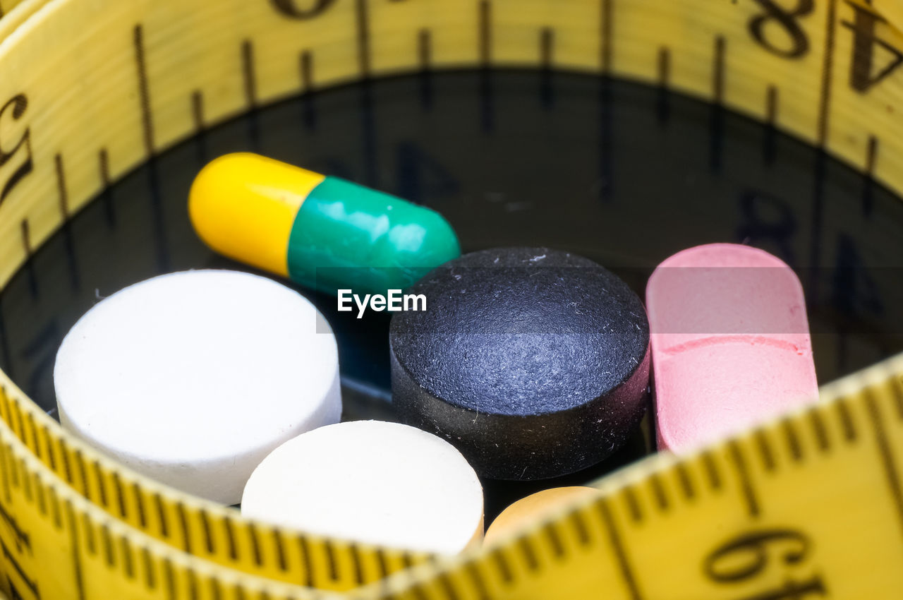 Close-up of tablets and tape measure on table