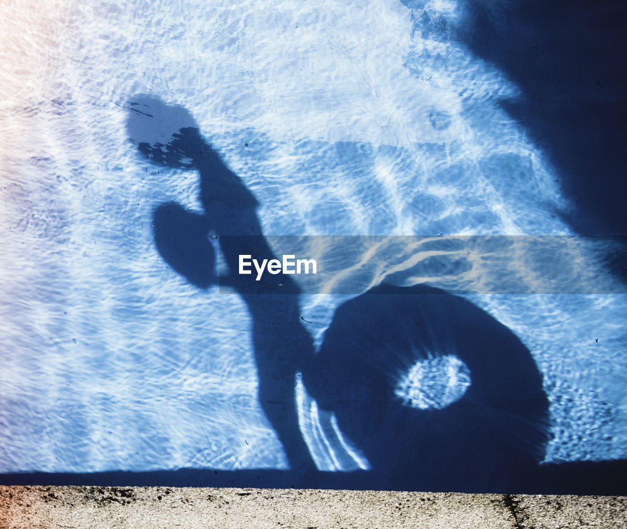 Shadow of woman in swimming pool