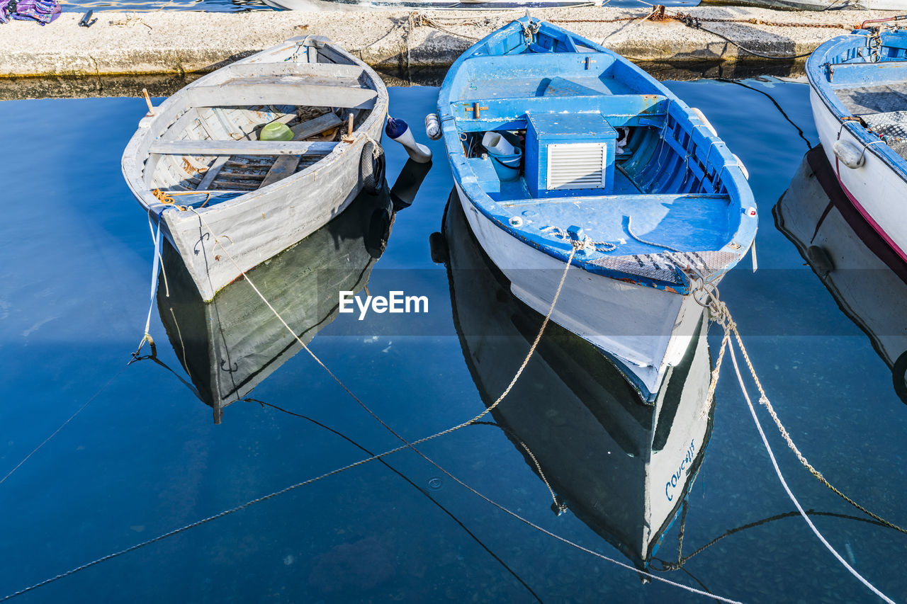 HIGH ANGLE VIEW OF FISHING BOAT MOORED AT SHORE