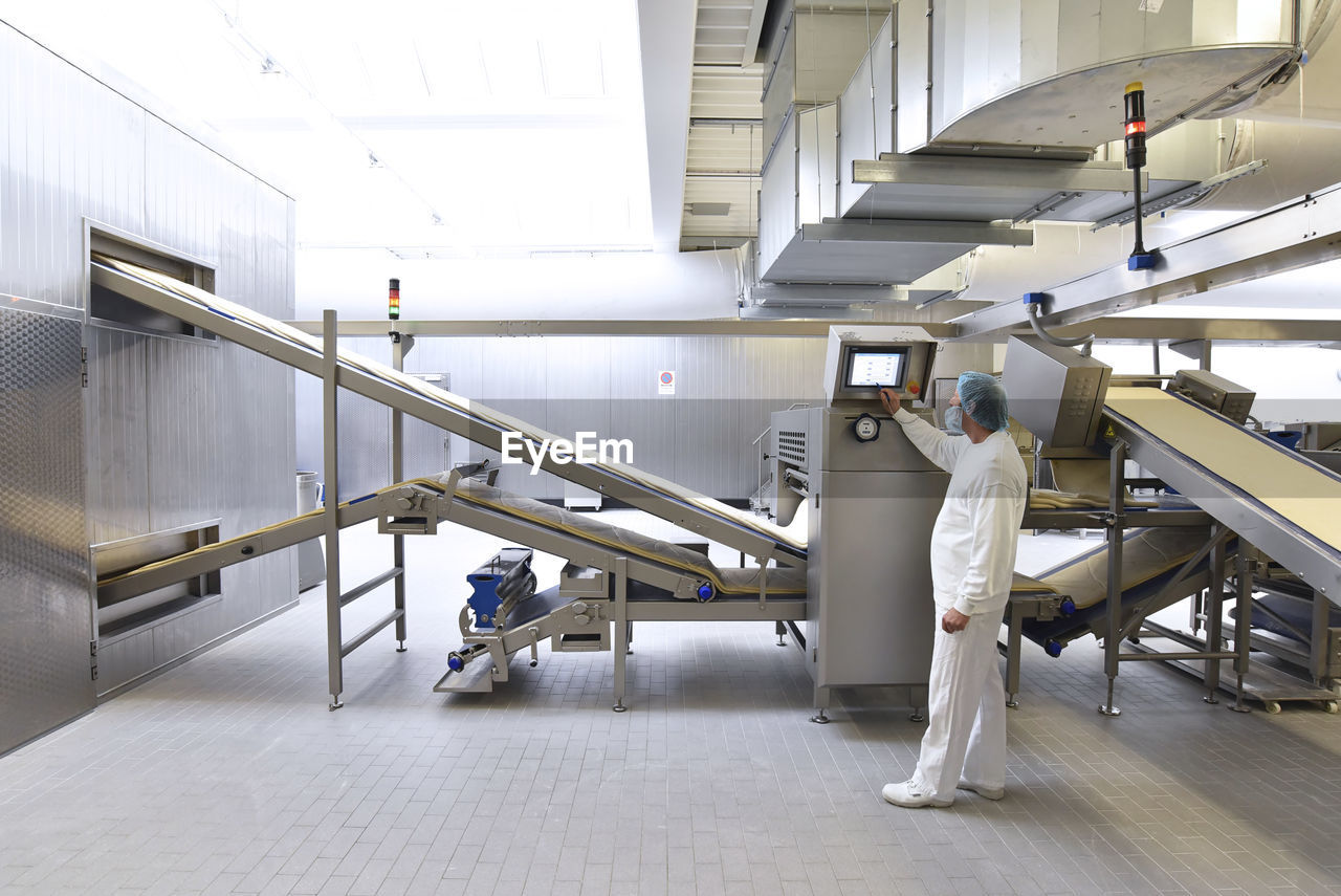 Worker operating machine in an industrial bakery