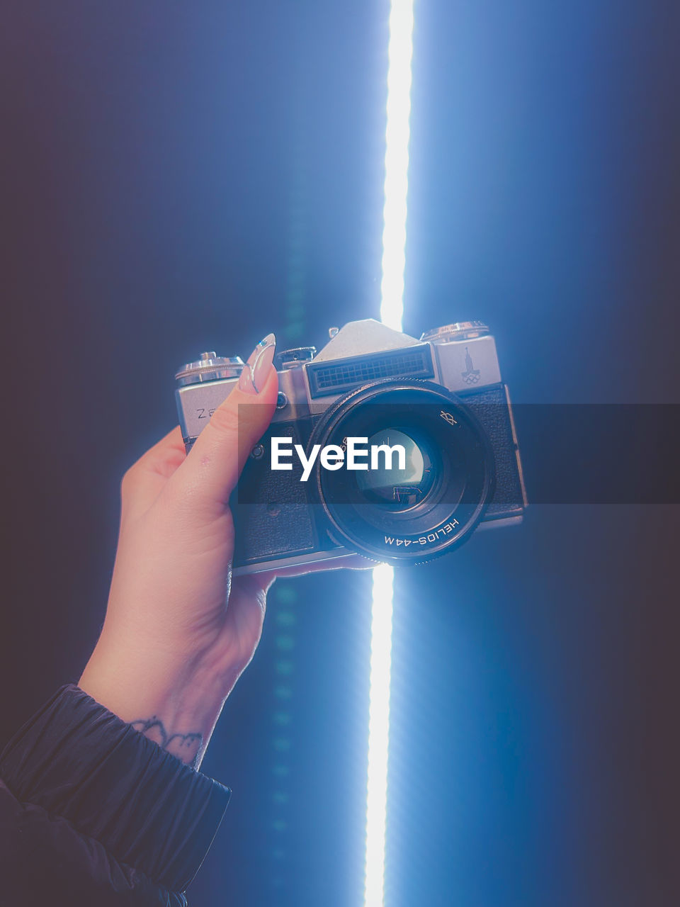 hand, one person, holding, technology, camera, blue, adult, light, activity, photographing, indoors, occupation, studio shot, copy space, photographer