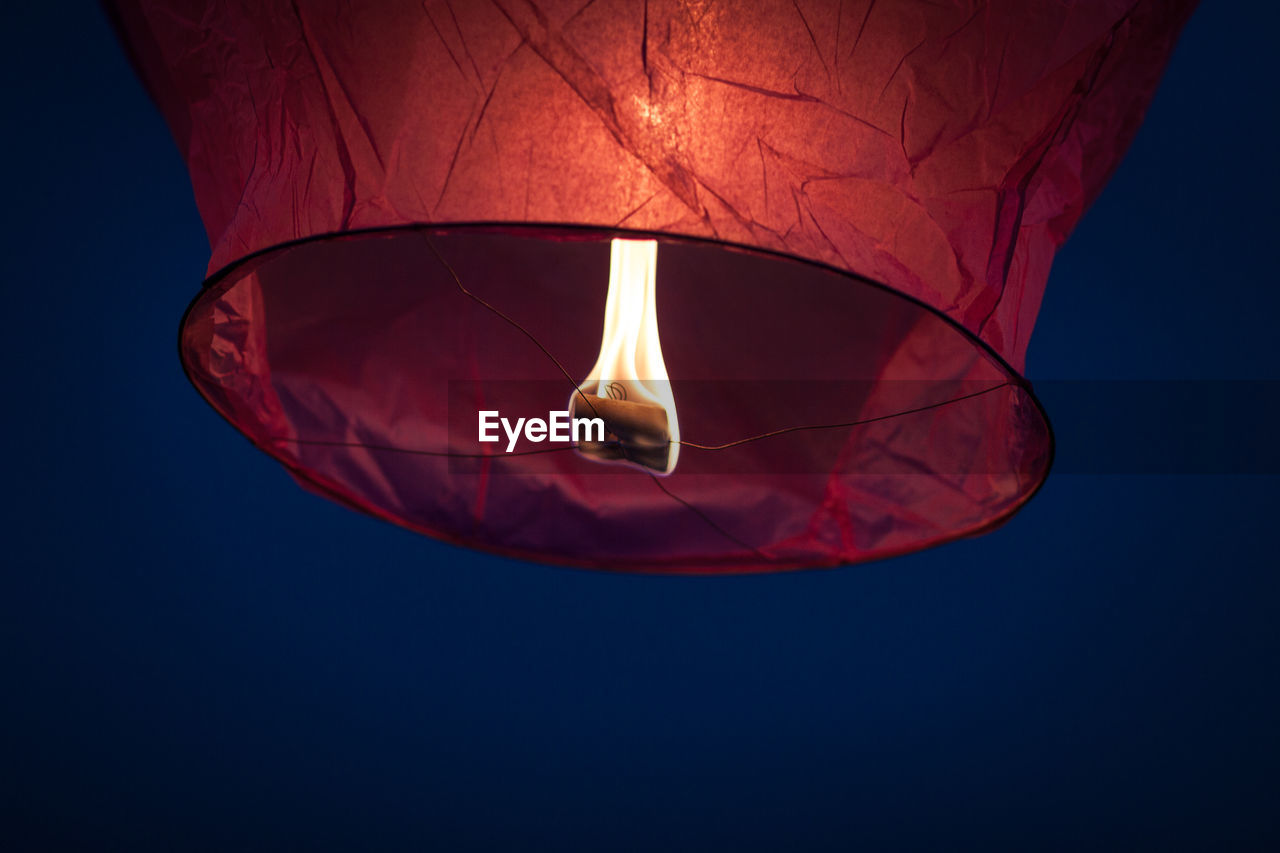 Low angle view of lit sky lantern at night
