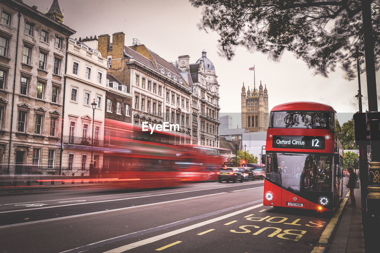 Double-decker bus on road in city during sunset