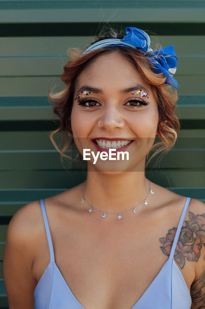 Smiling woman with headband and glittering eye make-up
