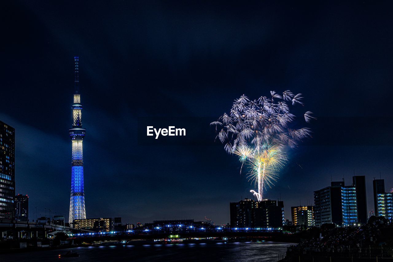 FIREWORK DISPLAY OVER ILLUMINATED BUILDINGS IN CITY