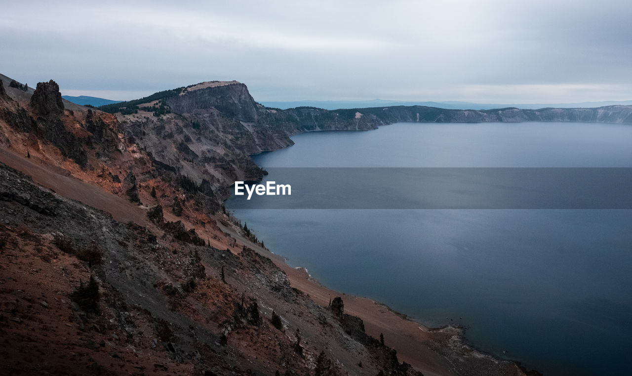 Scenic view of sea and mountains against sky