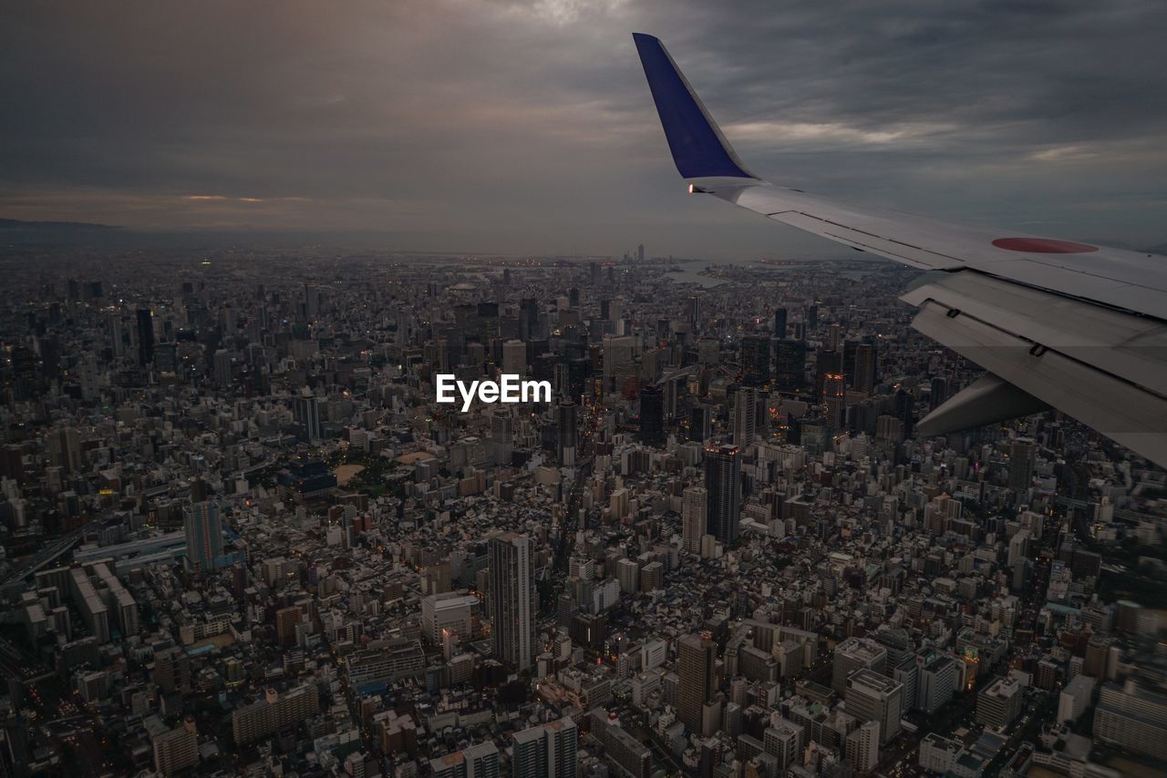 Cropped image of airplane flying over cityscape