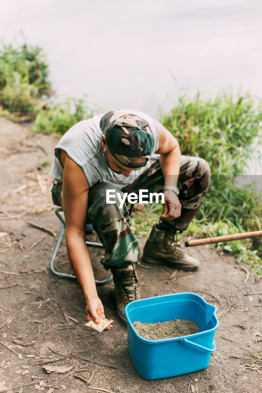 A young fisherman catches fish on a lake or river, prepares tackle and bait. hobbies