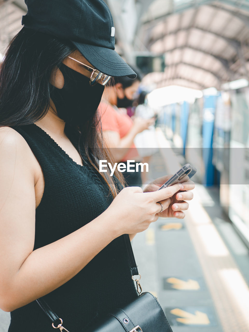 Close-up woman wear protective mask and using smartphone in public transport.