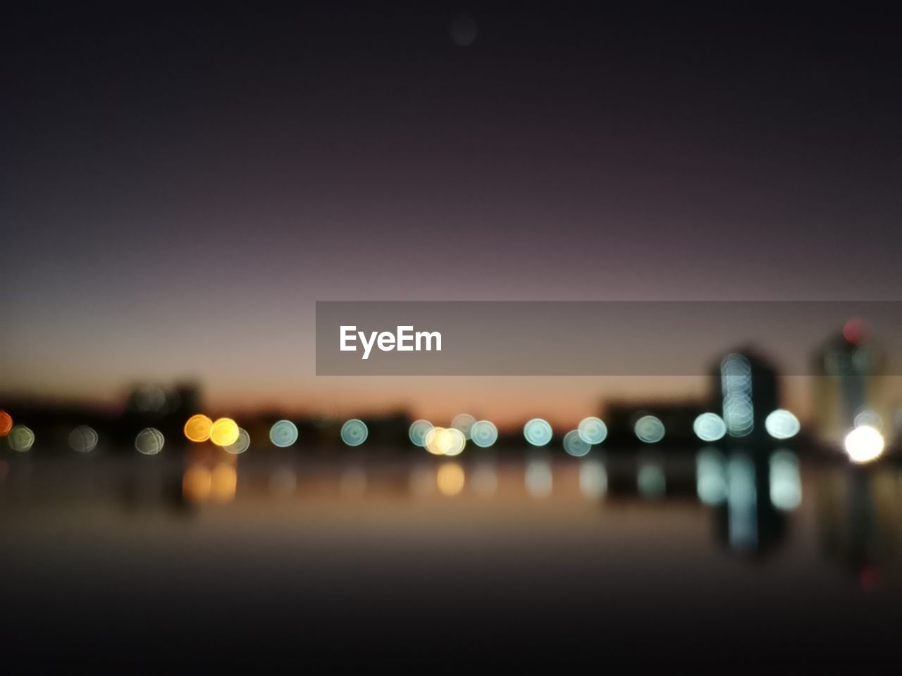 DEFOCUSED IMAGE OF ILLUMINATED LIGHTS IN CITY AT NIGHT