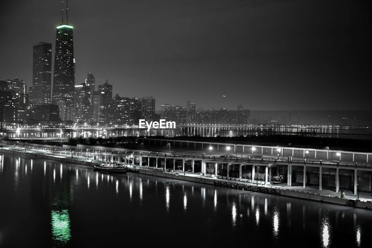 Illuminated navy pier in sea at city against sky