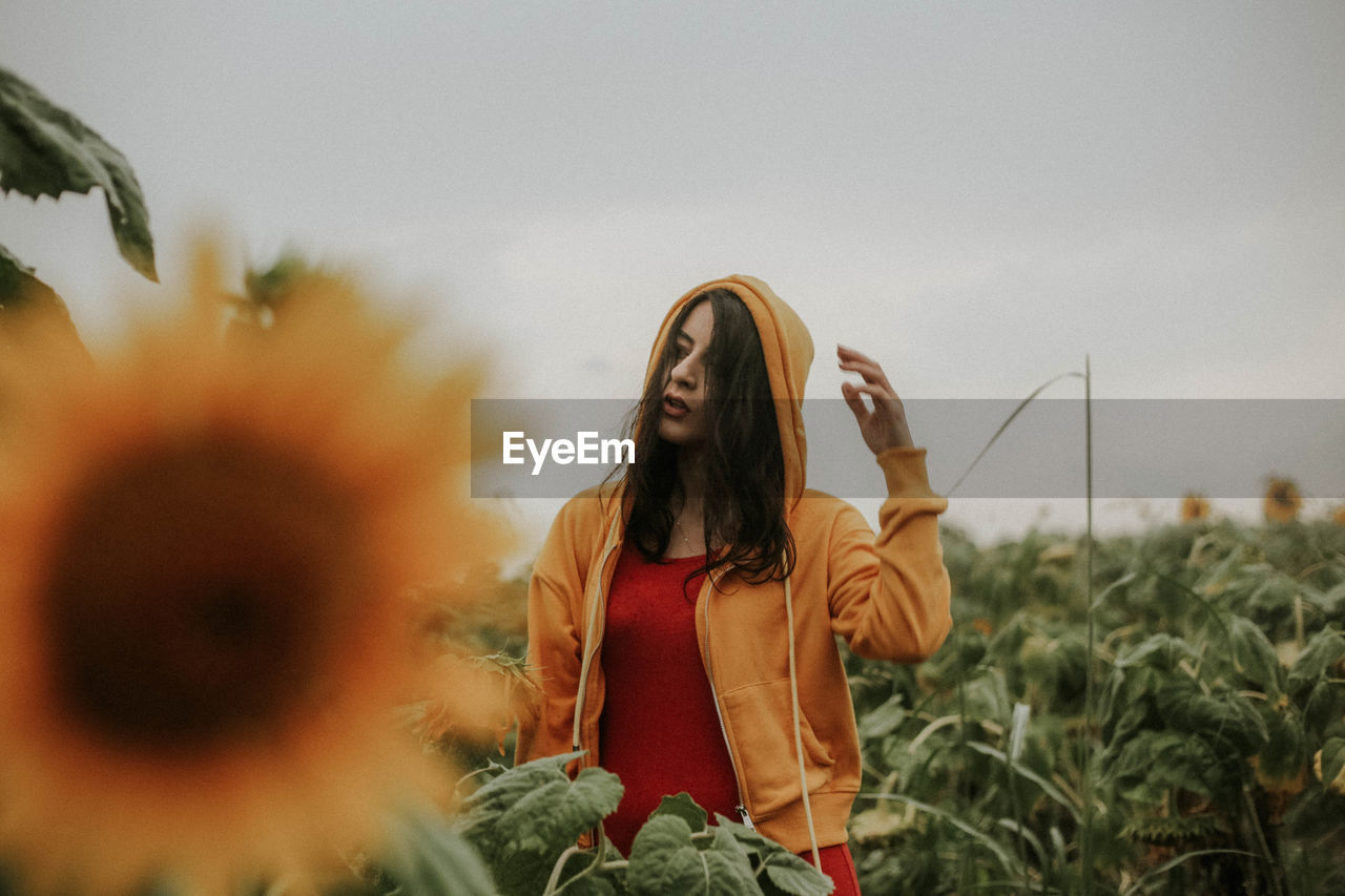 Young woman standing at sunflower farm