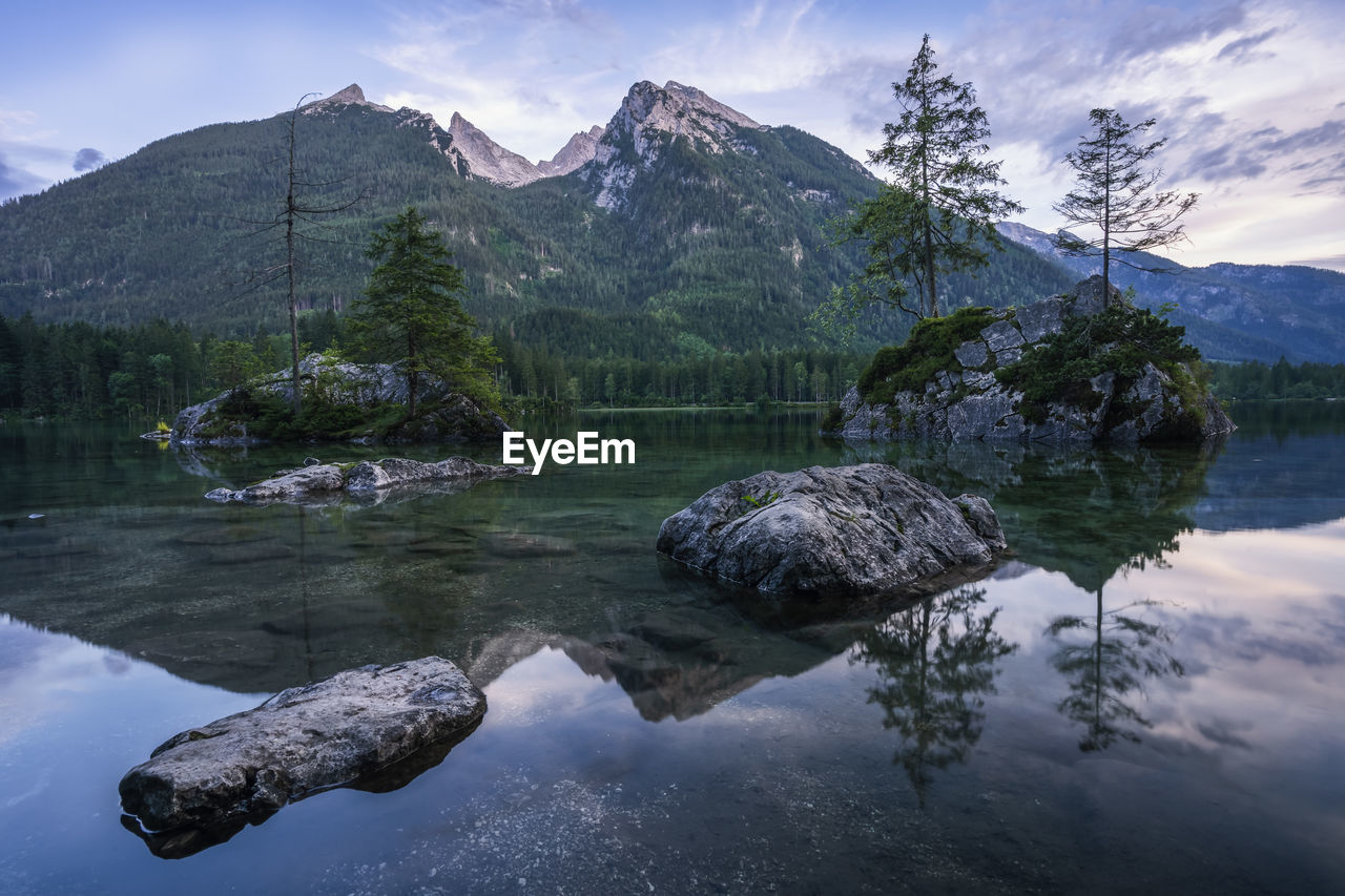 REFLECTION OF ROCKS IN LAKE AGAINST SKY