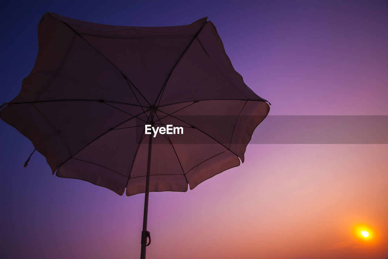 LOW ANGLE VIEW OF PARASOL AGAINST CLEAR SKY