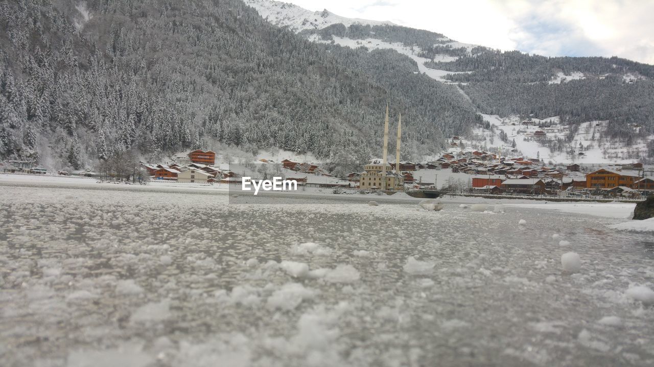 SNOW COVERED ROAD BY MOUNTAINS