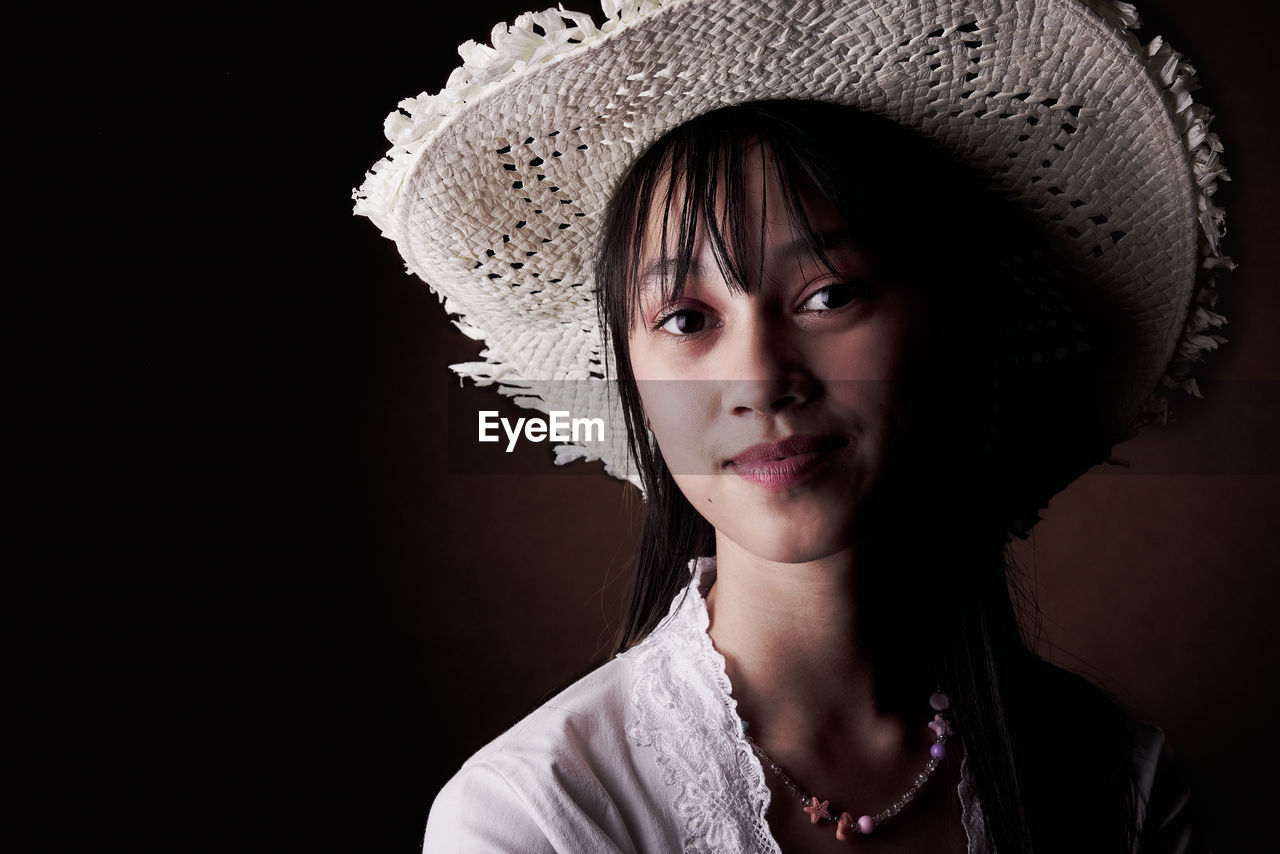 portrait, one person, headshot, hat, studio shot, clothing, women, adult, black background, looking at camera, young adult, indoors, fashion accessory, fashion, front view, female, serious, hairstyle, close-up, person, emotion, copy space, child, black, portrait photography, dark, human face, looking