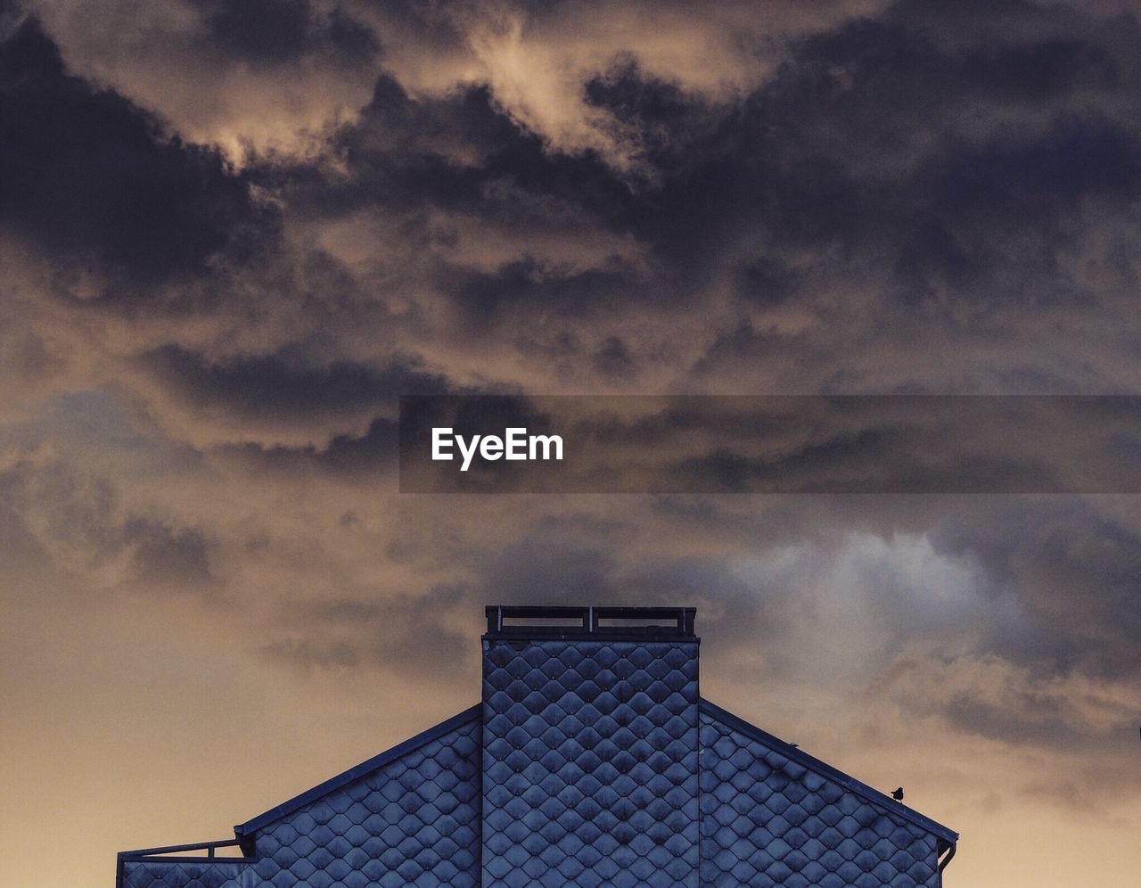 LOW ANGLE VIEW OF BUILDING AGAINST CLOUDY SKY