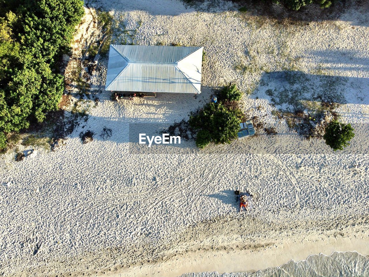 high angle view, sunlight, day, nature, beach, land, sand, shadow, plant, built structure, water, architecture, outdoors, tree, aerial photography, no people, building exterior, sunny, house, sea