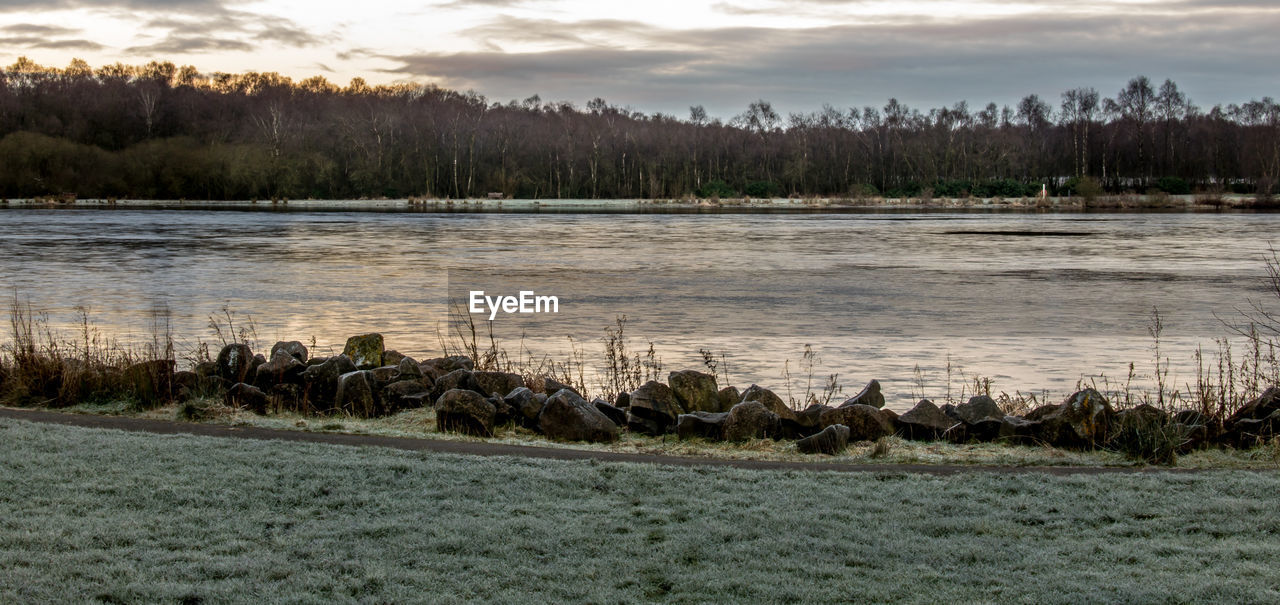 Scenic view of lake against cloudy sky