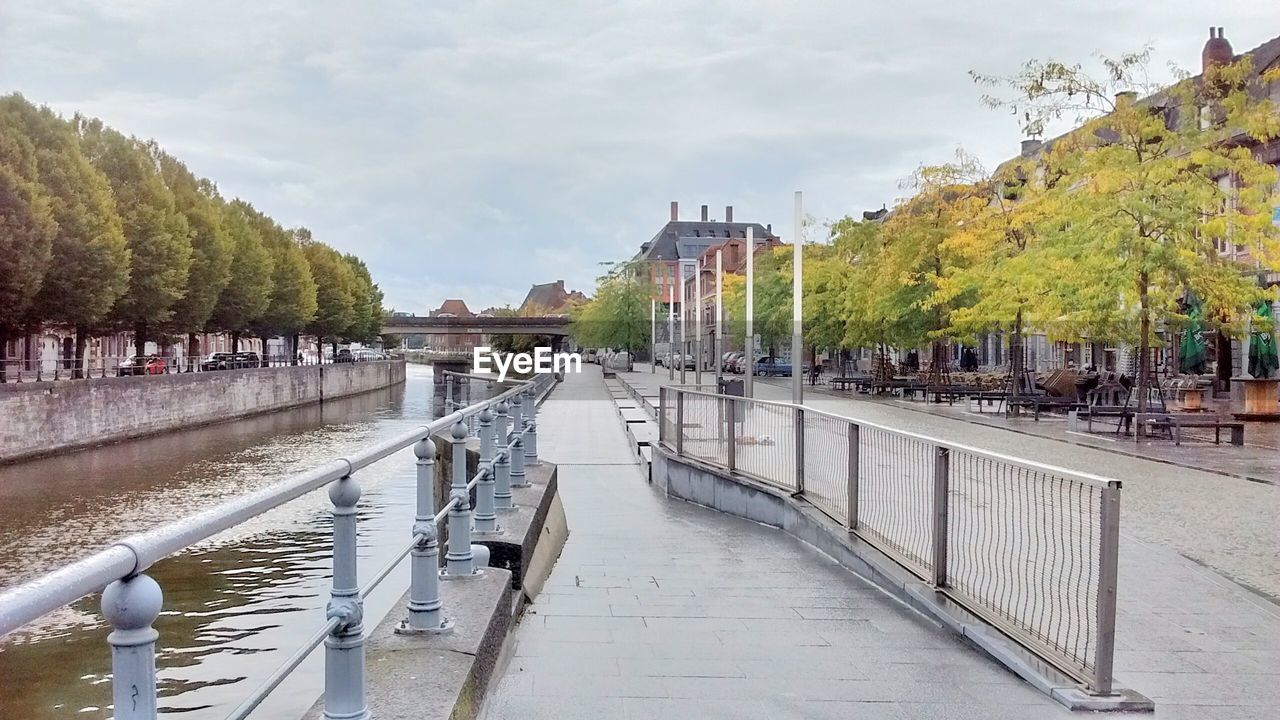 FOOTBRIDGE OVER RIVER WITH BUILDINGS IN BACKGROUND