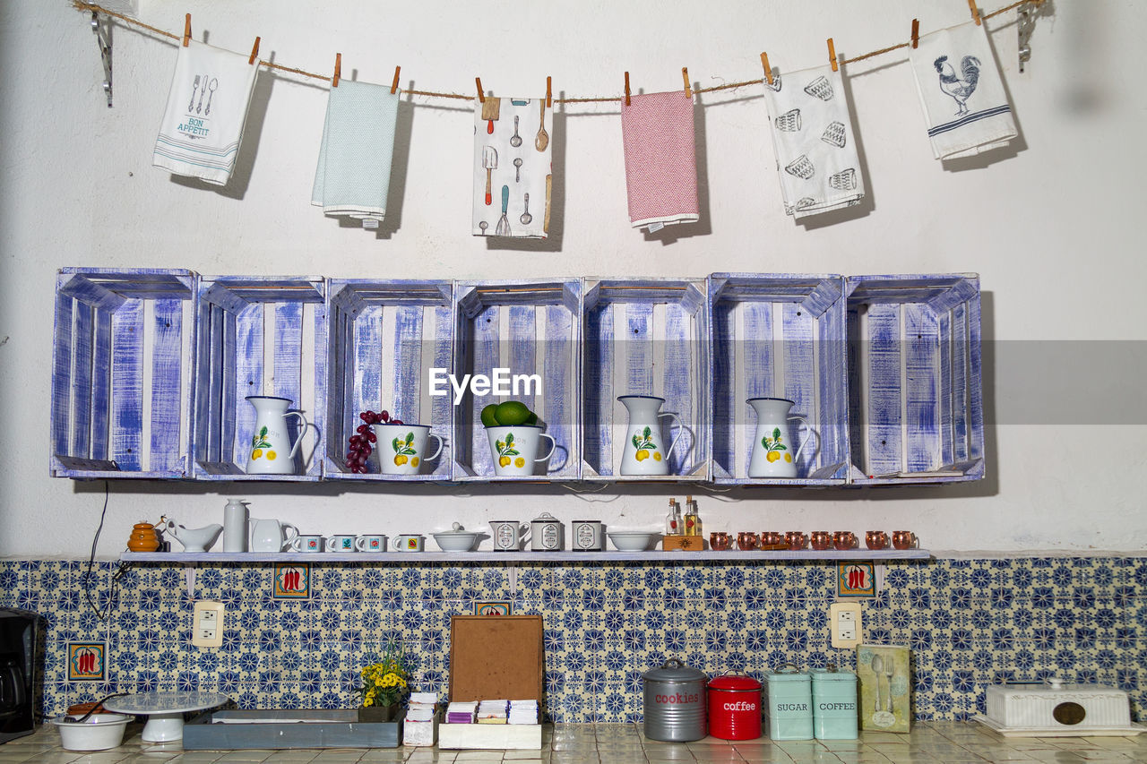 LOW ANGLE VIEW OF DECORATIONS HANGING AGAINST WALL AT HOME