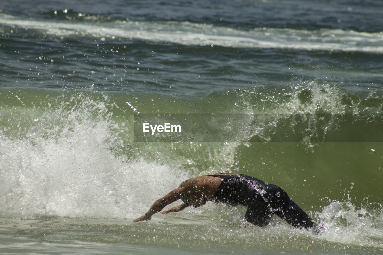 MAN SWIMMING IN SEA WATER FROM WOMAN