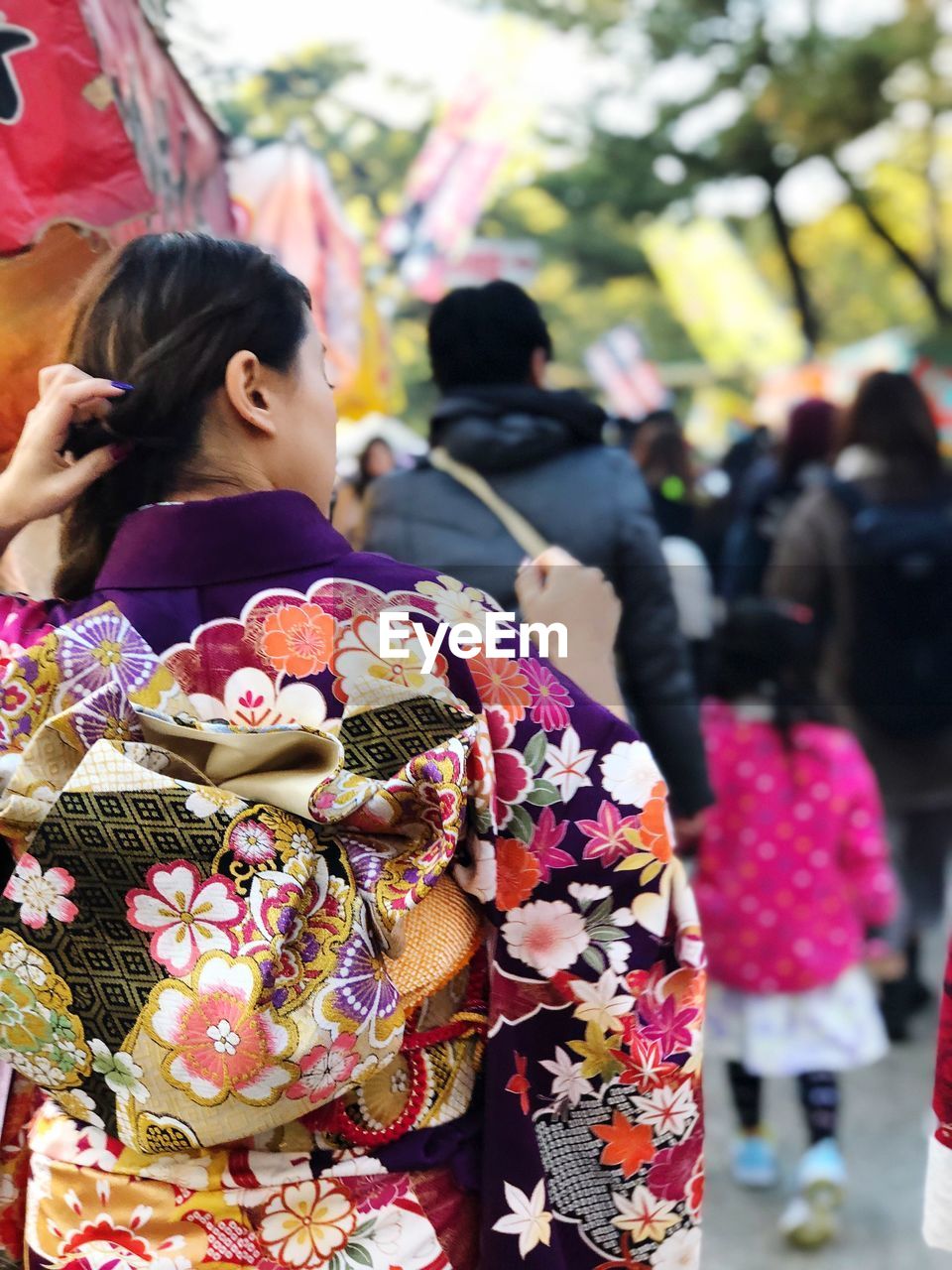 Rear view of woman in kimono on footpath