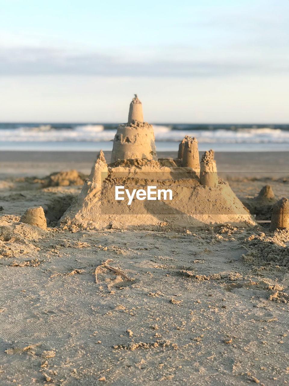 Sandcastle on beach against sky