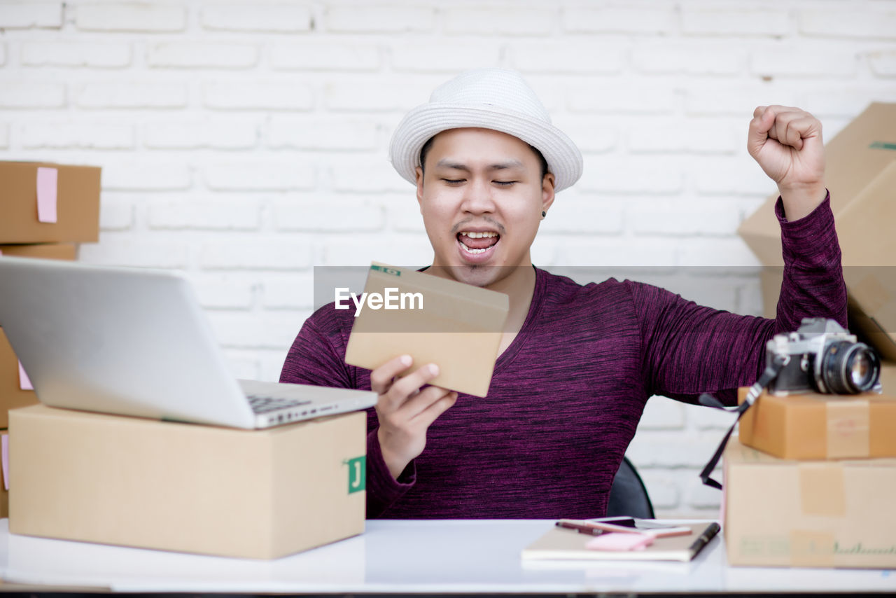 SMILING YOUNG MAN USING LAPTOP