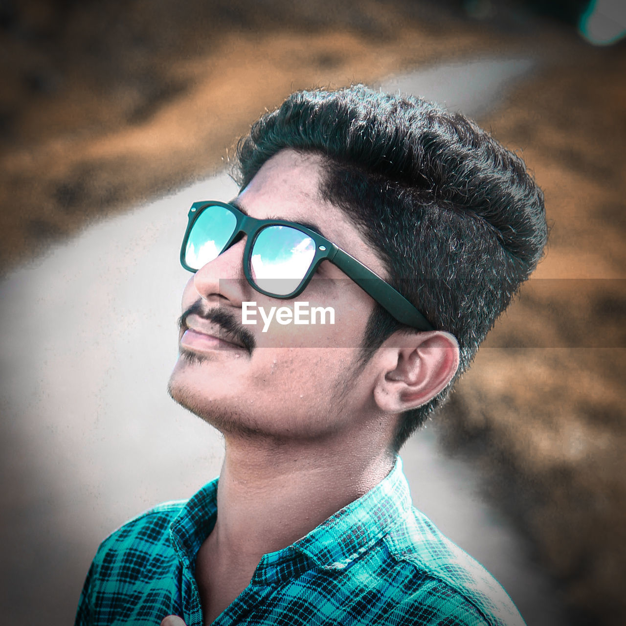 PORTRAIT OF YOUNG MAN WEARING SUNGLASSES OUTDOORS