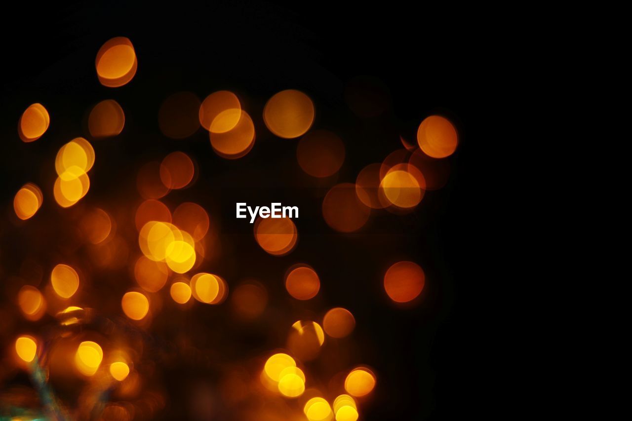 DEFOCUSED IMAGE OF ILLUMINATED LIGHTS AT NIGHT