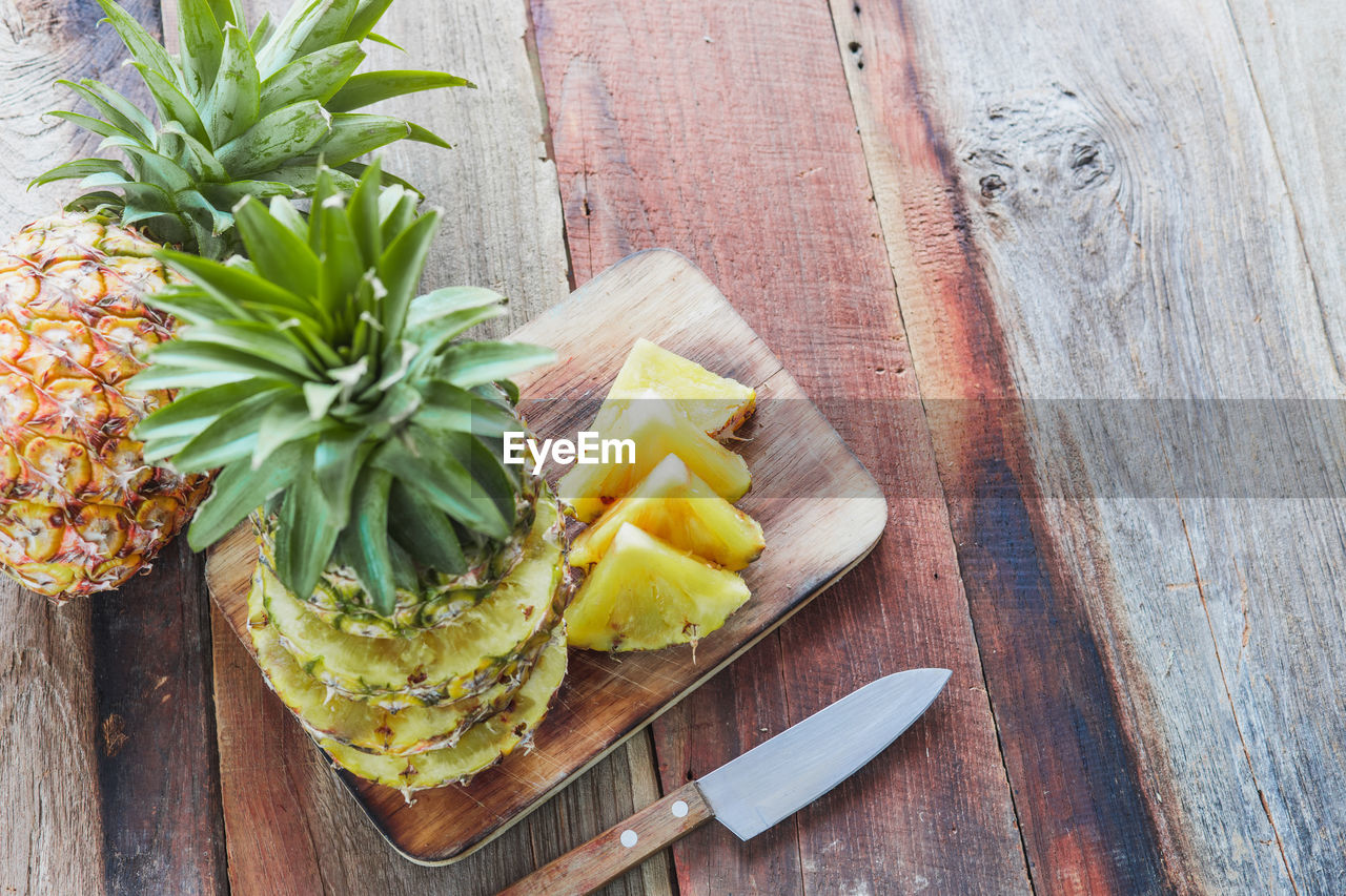 HIGH ANGLE VIEW OF CHOPPED FRUITS ON CUTTING BOARD