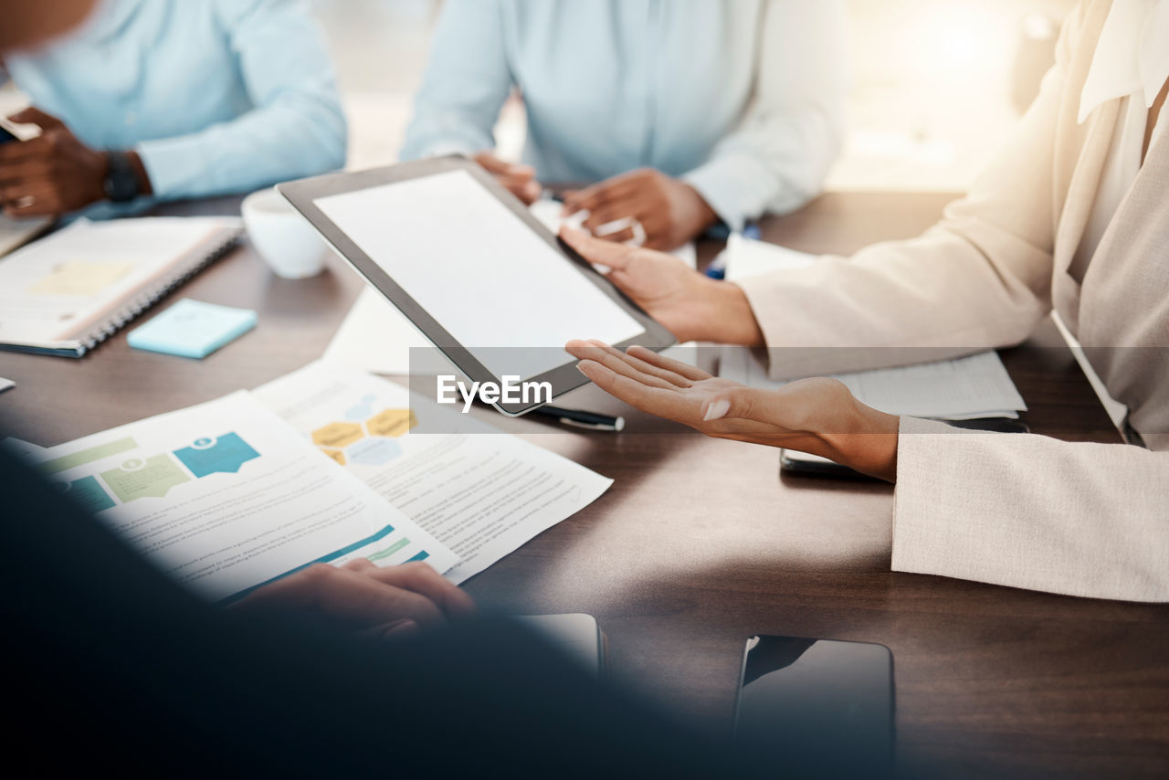 midsection of business colleagues working at desk