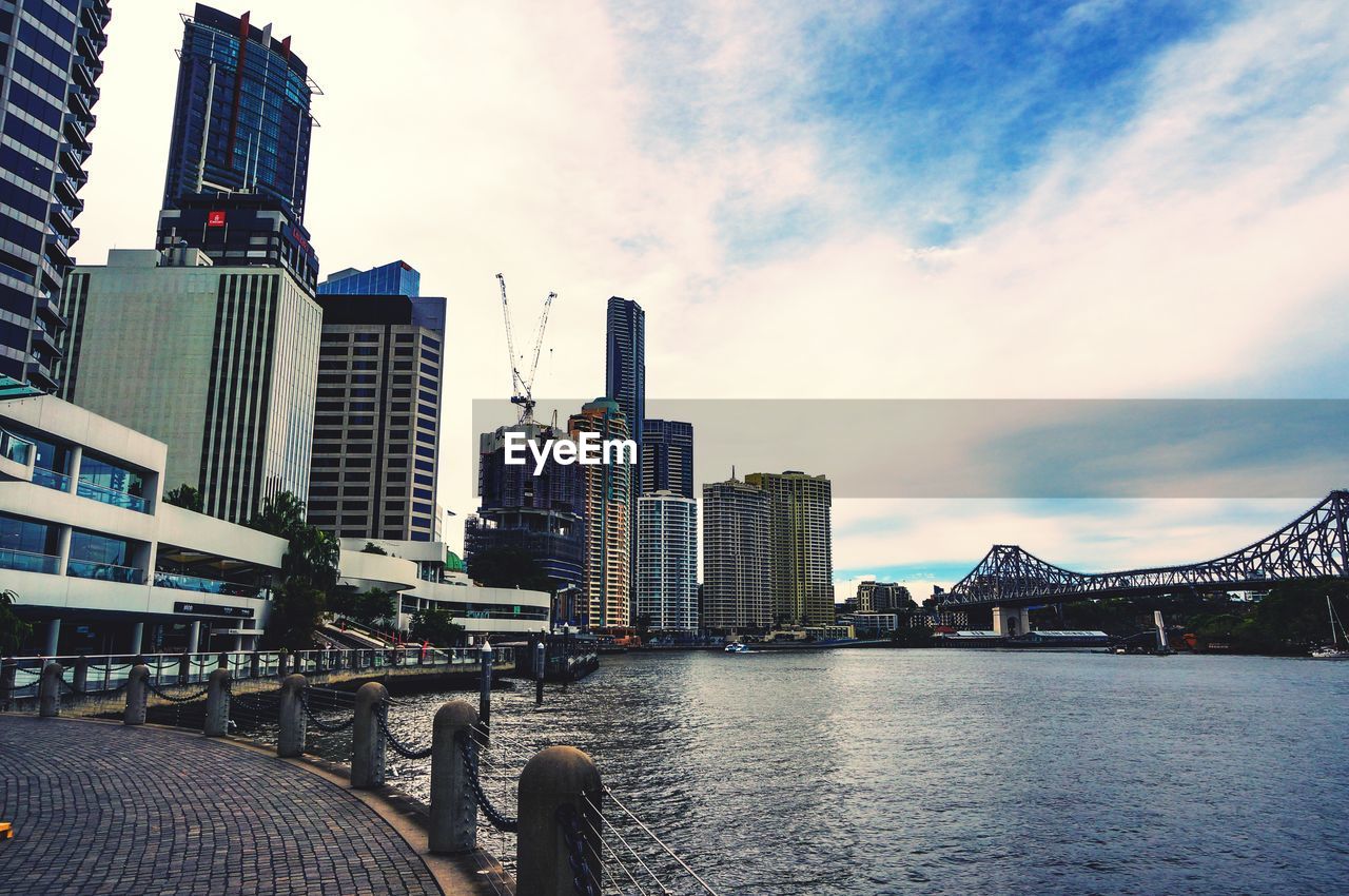 BRIDGE OVER RIVER AGAINST BUILDINGS IN CITY