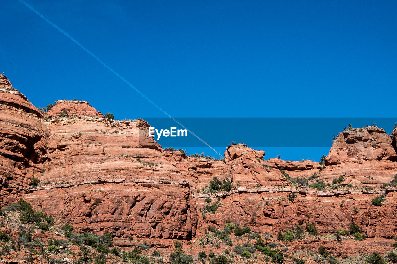 Low angle view of rock formation against clear blue sky