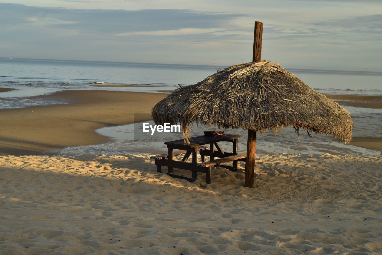  palm thatched beach umbrella on the sea of cortez at low tide, in san felipe, baja, mexico