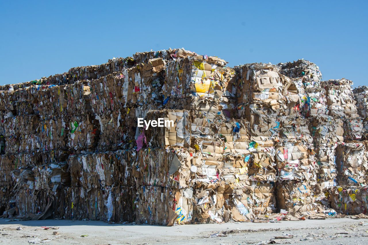 LOW ANGLE VIEW OF GARBAGE STACK AGAINST SKY