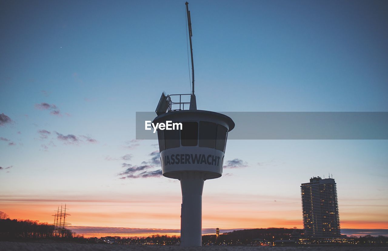 Low angle view of observation tower against orange sky