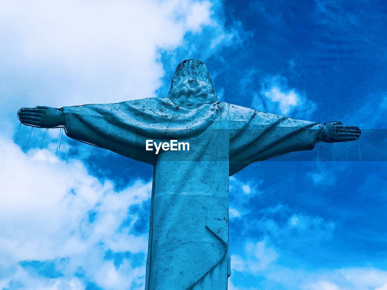 Low angle view of hand against blue sky