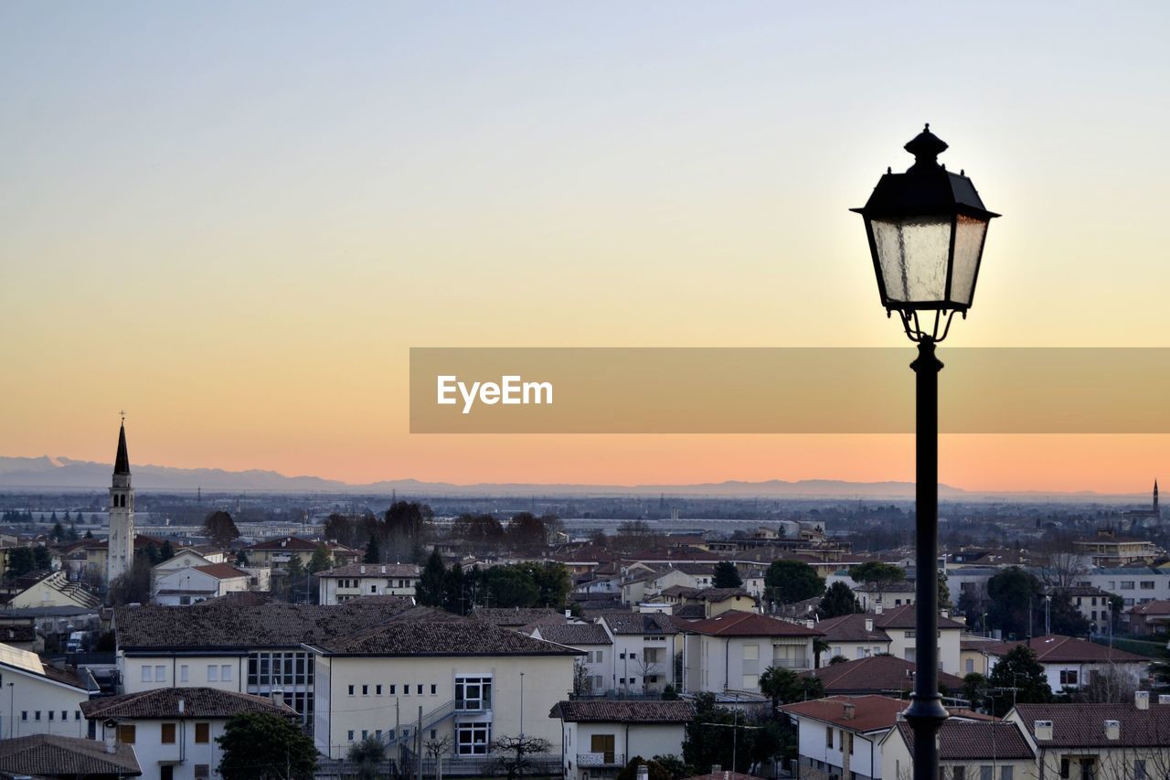 STREET LIGHT AND BUILDINGS IN TOWN AGAINST SKY