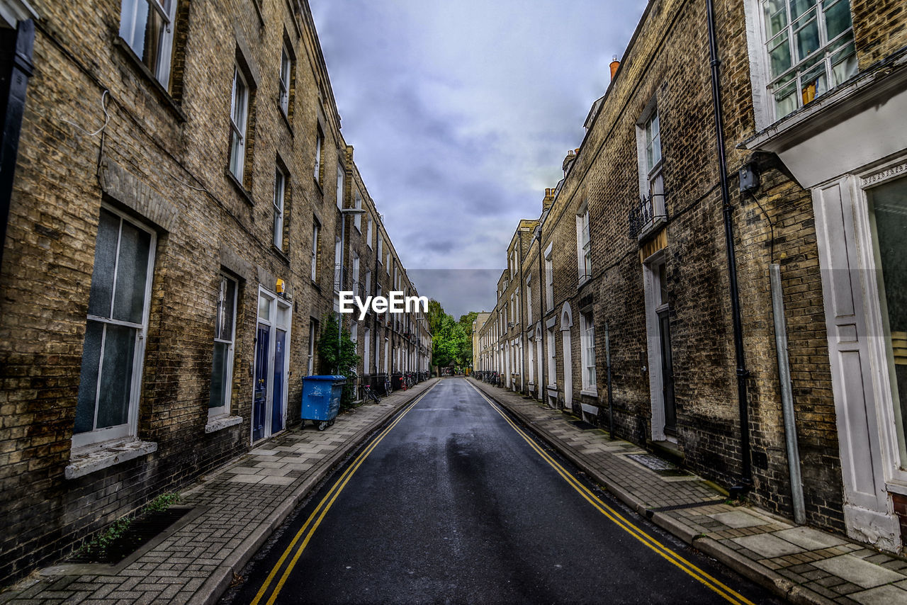 Empty road amidst buildings in city