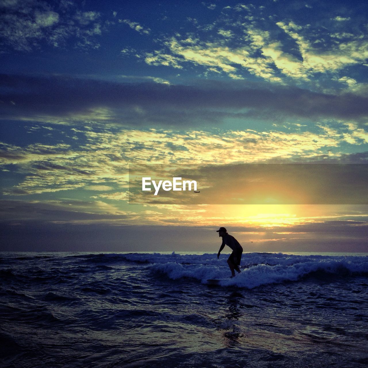 Side view of a silhouette person surfing in the sea