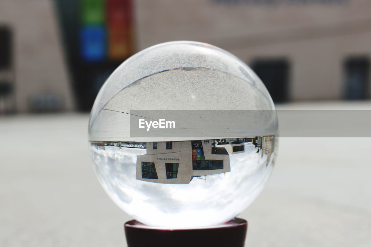 CLOSE-UP OF CRYSTAL BALL WITH REFLECTION ON GLASS