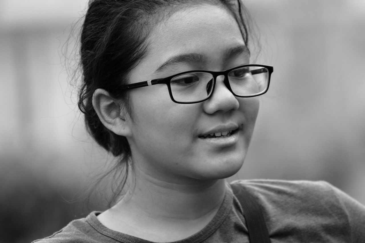 Black and white portrait of a natural look of a young girl wearing glasses 