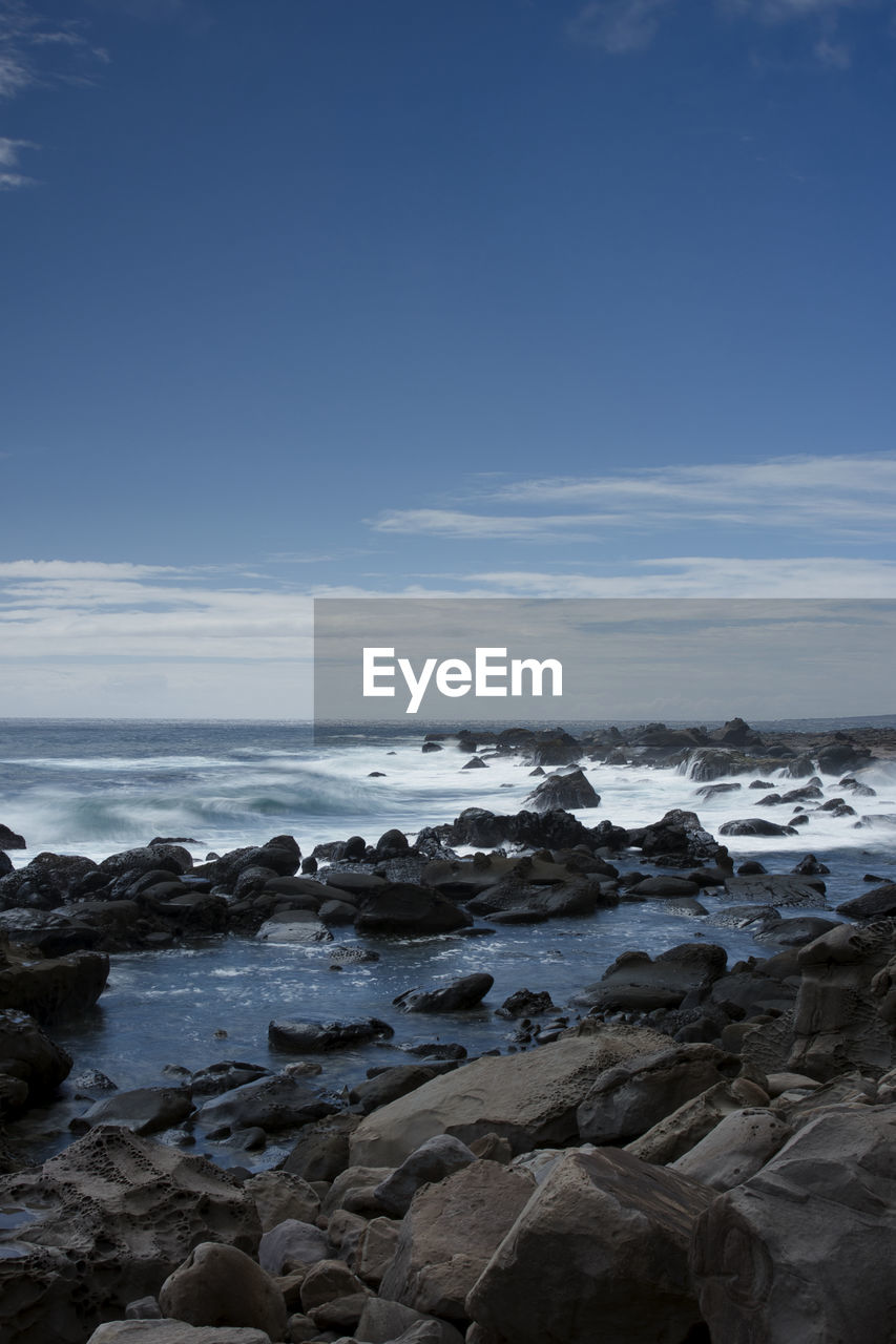 Rocks on beach against sky