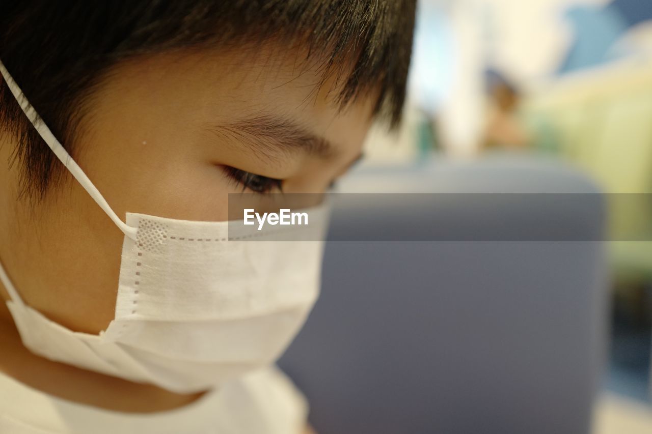 Close-up portrait of boy wearing surgical mask