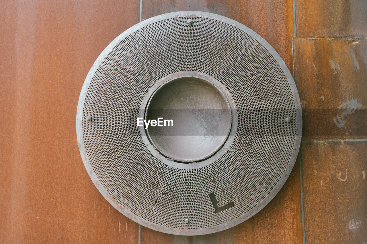 Close-up of speaker on wooden wall